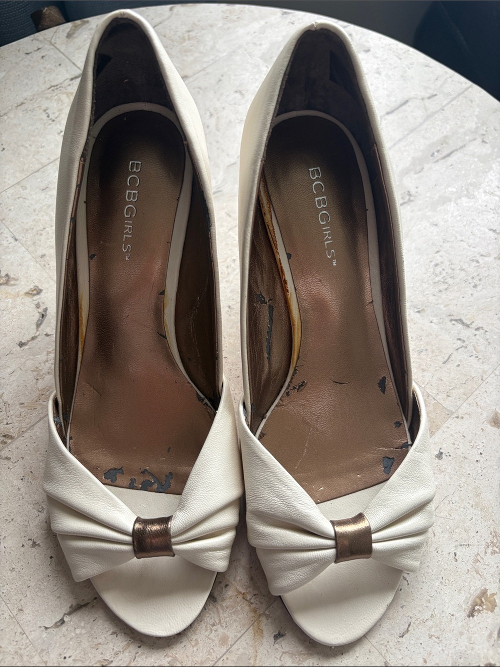 BCBGirls Cream Bow Peep-Toe Pumps with Metallic Accent